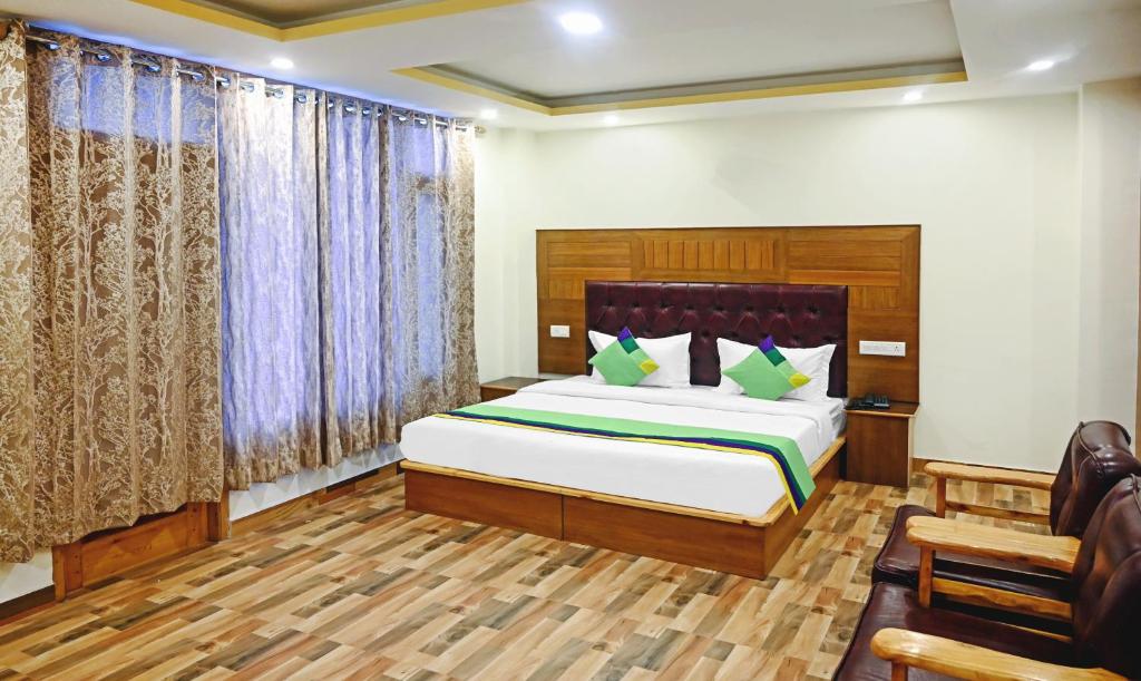 a bedroom with a bed and a chair in it at Treebo Trend Dev With Valley View, Mall Road in Manāli