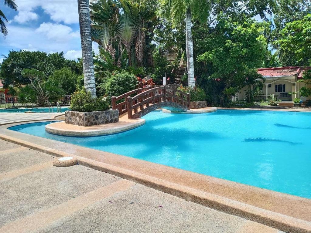 una gran piscina azul con una valla de madera alrededor en RedDoorz Plus @ Costa Roca Balamban en Cebú