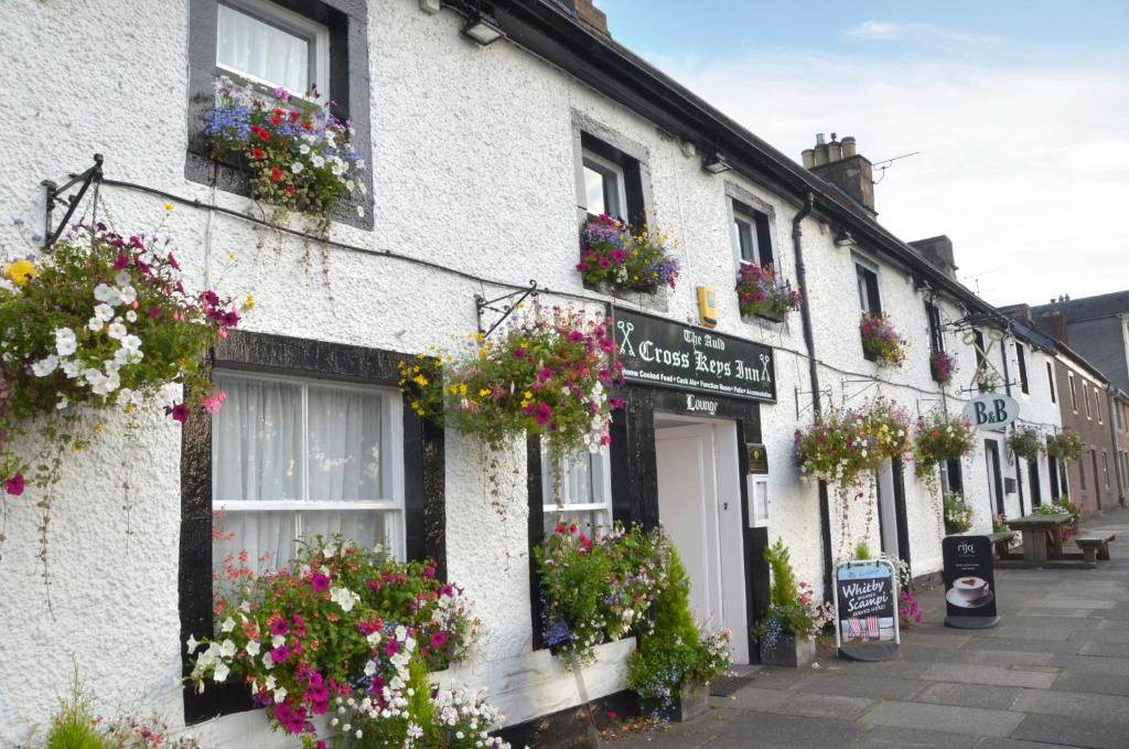 a white building with flowers in the window boxes at Auld Cross Keys Inn in Jedburgh