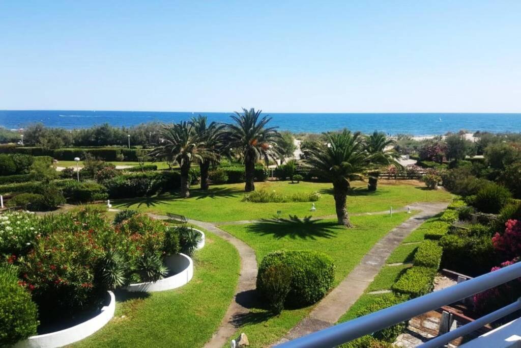 - une vue sur un parc planté de palmiers et de buissons dans l'établissement Vue mer exceptionnelle, à La Grande Motte