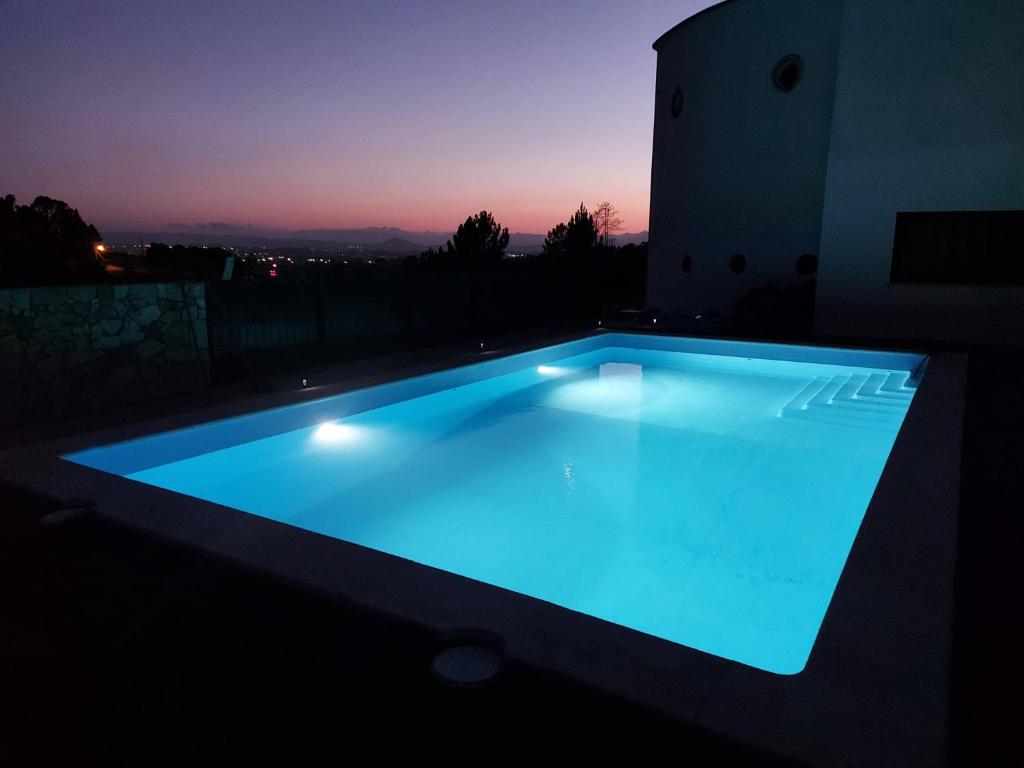 uma piscina iluminada de azul à noite em Casa Valverde em Cartaxo