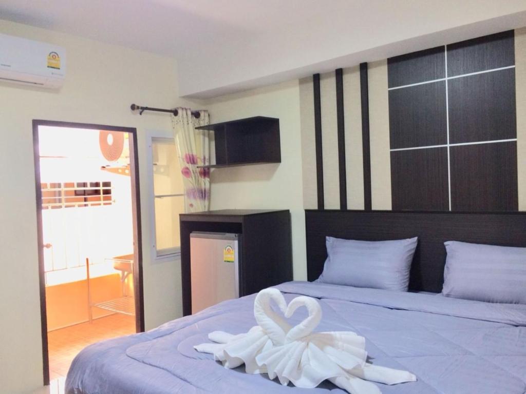 ein Zimmer mit einem Bett mit einem Herztuch darauf in der Unterkunft Pangviman Residence in Ban Prong Phra Bat Nok