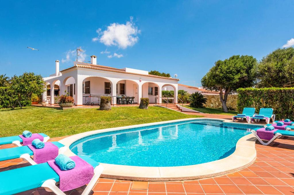 a villa with a swimming pool in front of a house at Villa Xaloc Blanes by Villa Plus in Cala Blanca