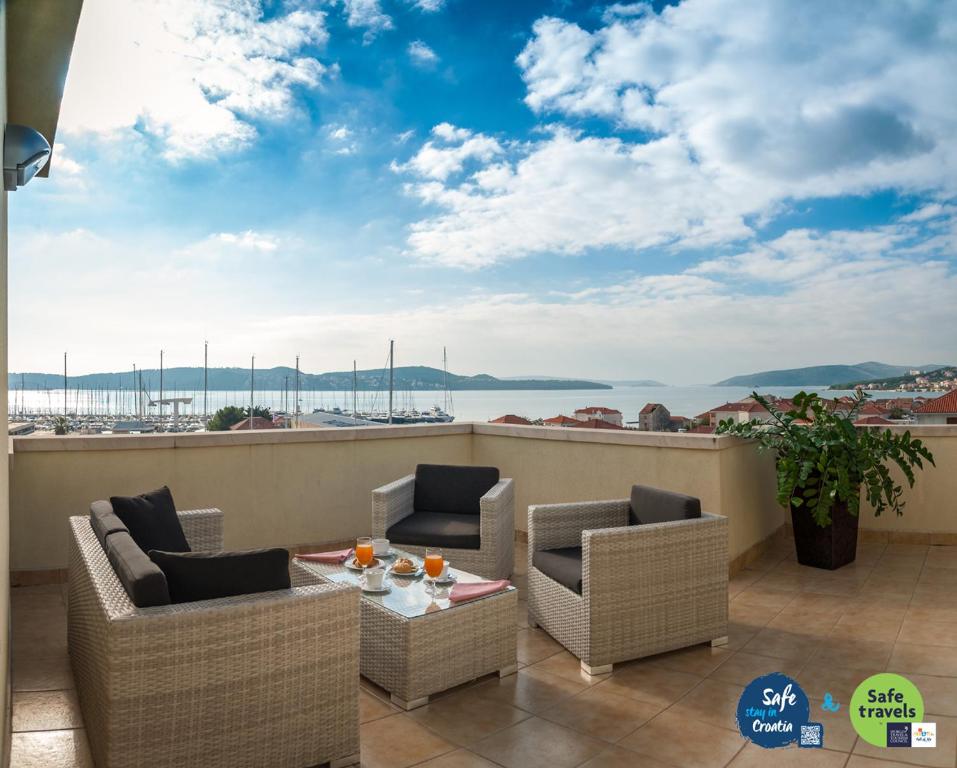 a balcony with chairs and a table with a view of the ocean at Hotel Rotondo in Trogir