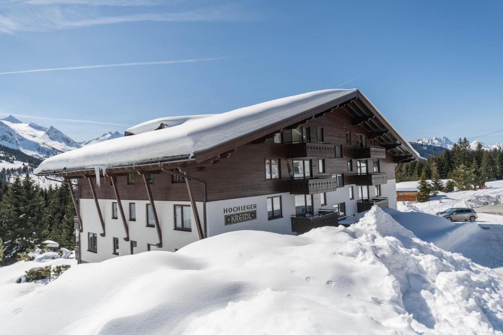 a snow covered building with a pile of snow at Haus Kreidl - Top 7 in Königsleiten