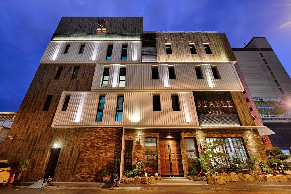 ein hohes Gebäude mit einem Gebäude in der Unterkunft STABLE HOTEL in Anping