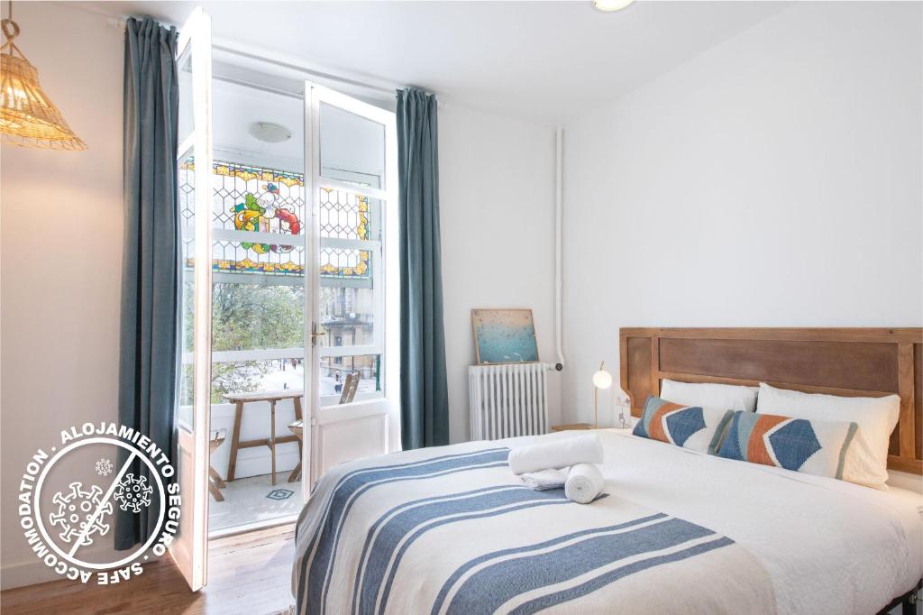 1 dormitorio con 1 cama y ventana con silla en Belle Époque Self-check-in Guesthouse - Adults-Only en San Sebastián