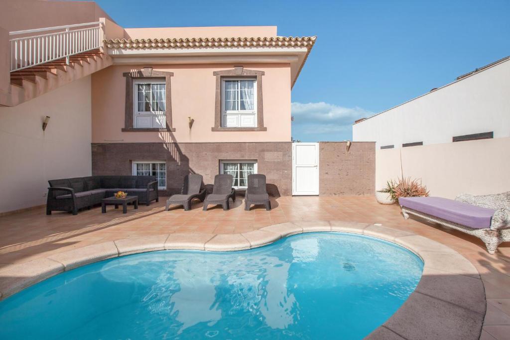 a swimming pool in front of a house at Villa Orquídea in El Médano