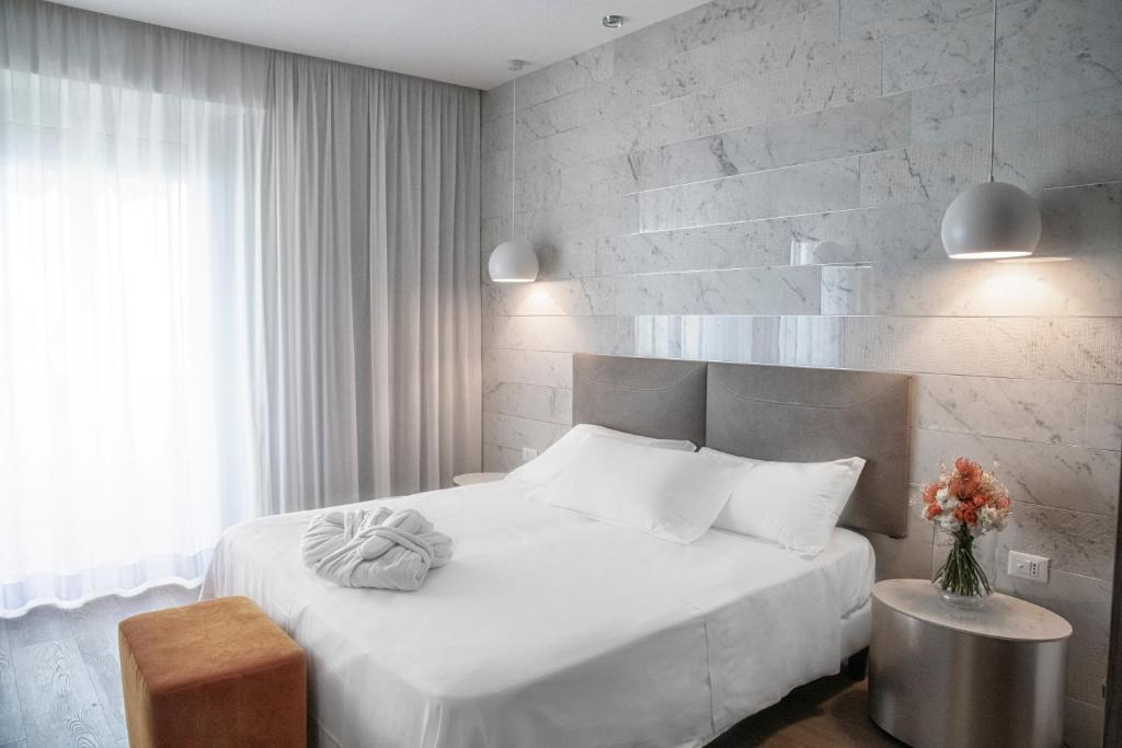a bedroom with a white bed and a brick wall at AmbientHotels Panoramic in Rimini