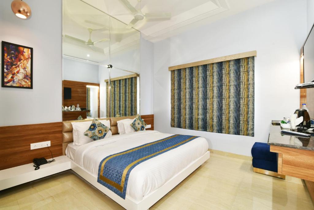 a bedroom with a large bed and a desk at Hotel Vacation Inn in Amritsar