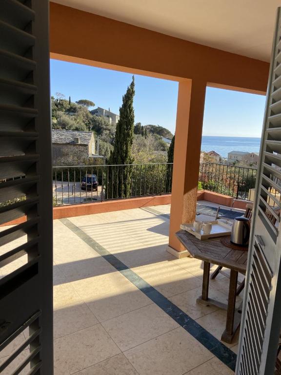 un balcon avec une table et une vue sur l'océan dans l'établissement Erbalunga - Résidence Les Bosquets - Cap corse Location, à Brando