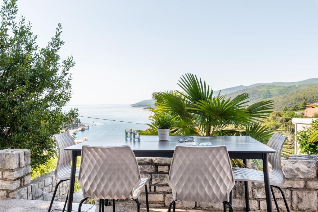 a table and chairs with a view of the ocean at Apartments Zulijani House Helis B1 & B6 in Rabac