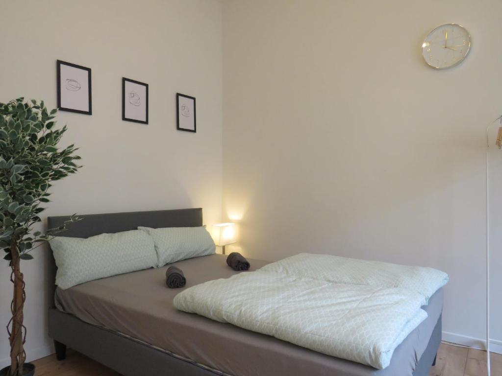 a bedroom with a bed and a clock on the wall at L8 Street Monteurwohnung - Mönsheim in Mönsheim
