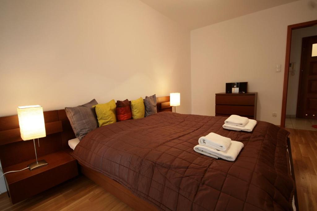 a bedroom with a large bed with two towels on it at LeoApart Czysta in Wrocław