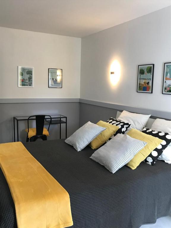 a bedroom with a bed with pillows on it at le 25 l'océan in Saint-Hilaire-de-Riez