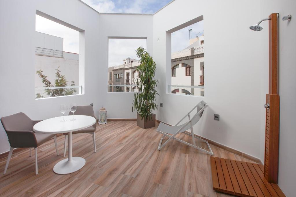 a white living room with a table and chairs at Gran Marina Suites in Las Palmas de Gran Canaria