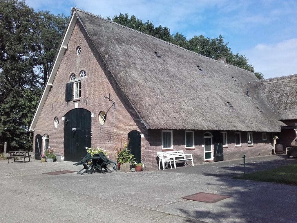 een groot bakstenen gebouw met een groot dak bij Boerderij De Aarnink in Heeten