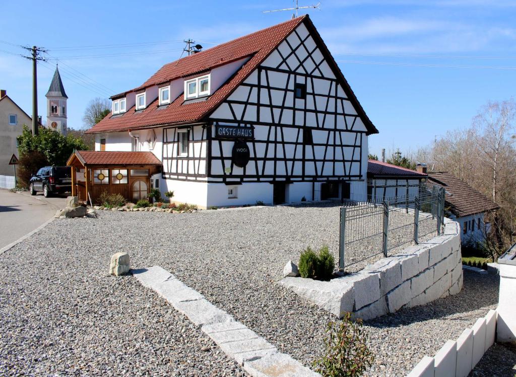 a black and white building with a red roof at Pension WoGi in Wolfegg