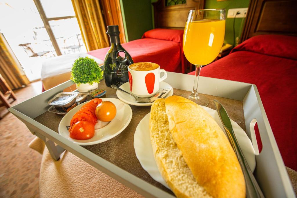 einen Tisch mit einer Schachtel Essen und einem Glas Orangensaft in der Unterkunft Hotel Arunda II in Ronda