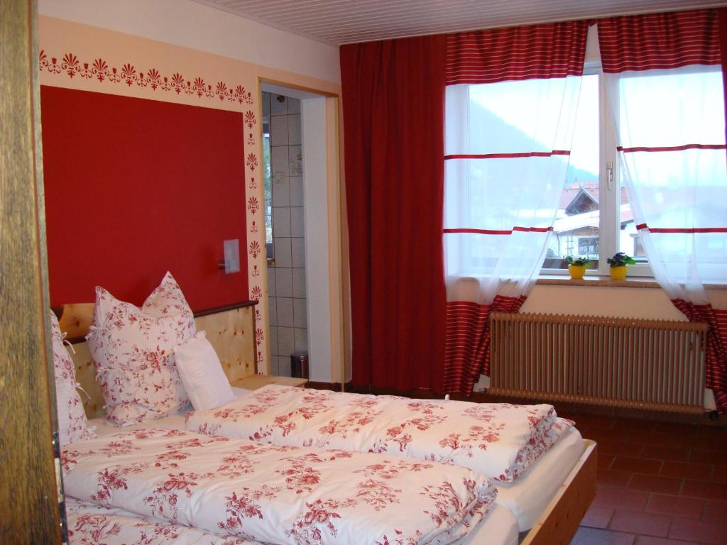 una camera da letto con un letto con pareti e finestre rosse di Gästehaus Christine a Langkampfen