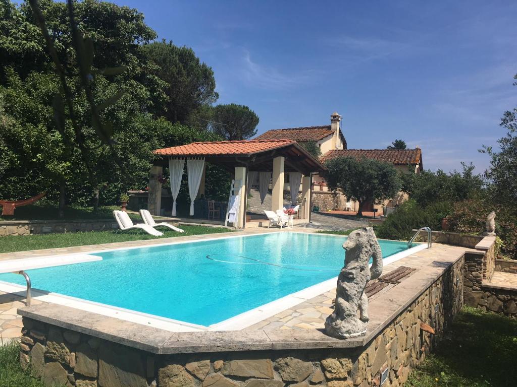 una estatua de oso sentada junto a una piscina en Podere Belvedere - Villa with private swimming-pool en Carmignano