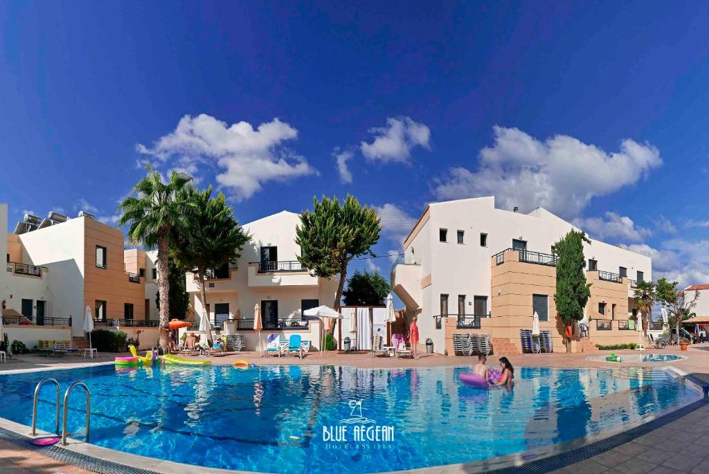 a swimming pool at a resort with white buildings at Blue Aegean Hotel & Suites in Gouves
