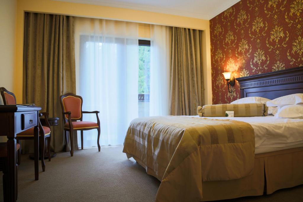 Postel nebo postele na pokoji v ubytování Hotel Foisorul cu Flori