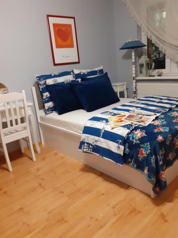 a bedroom with a bed with a blue and white comforter at Mieszkanie przy plaży Ela in Dziwnów