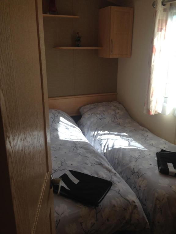 a bedroom with a bed with a laptop on it at Caravan ( Static, within a super holiday park ) in Birchington