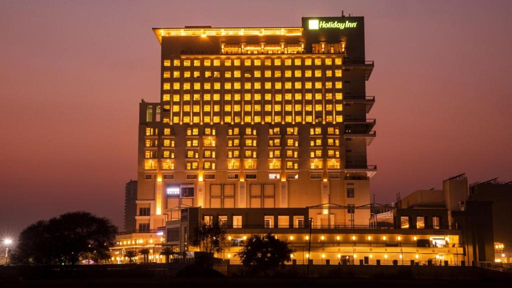 un edificio iluminado con un cartel encima en Holiday Inn Gurugram Sector 90, an IHG Hotel en Gurgaon