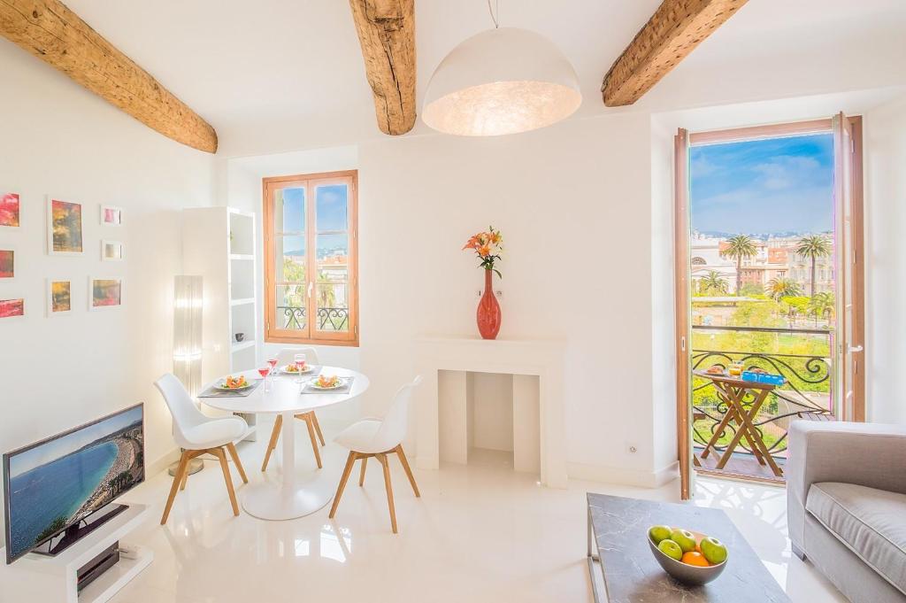 sala de estar blanca con mesa y TV en Sunlight Properties - BO - Hyper central, balcony, 5 mins to the beach, en Niza