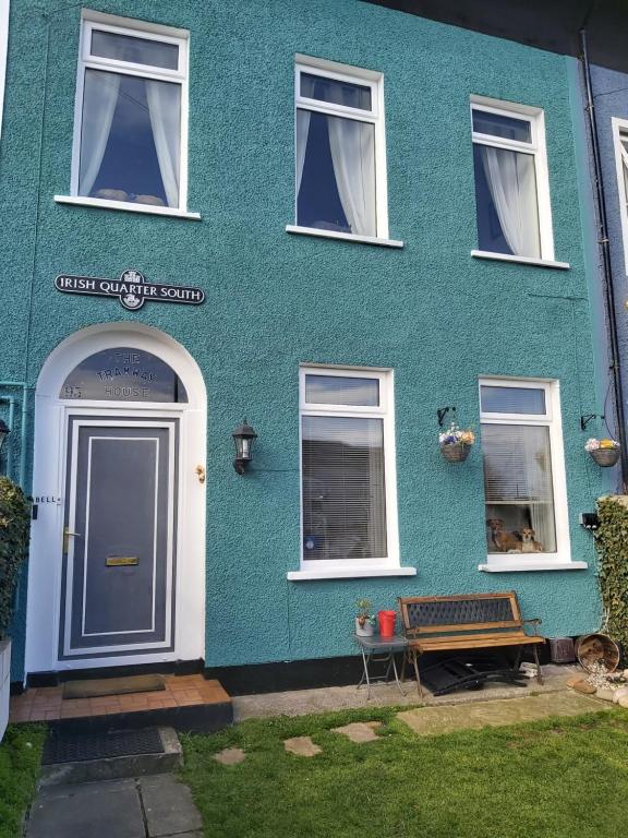 una casa azul con un perro sentado en la ventana en The Tramway House, en Carrickfergus