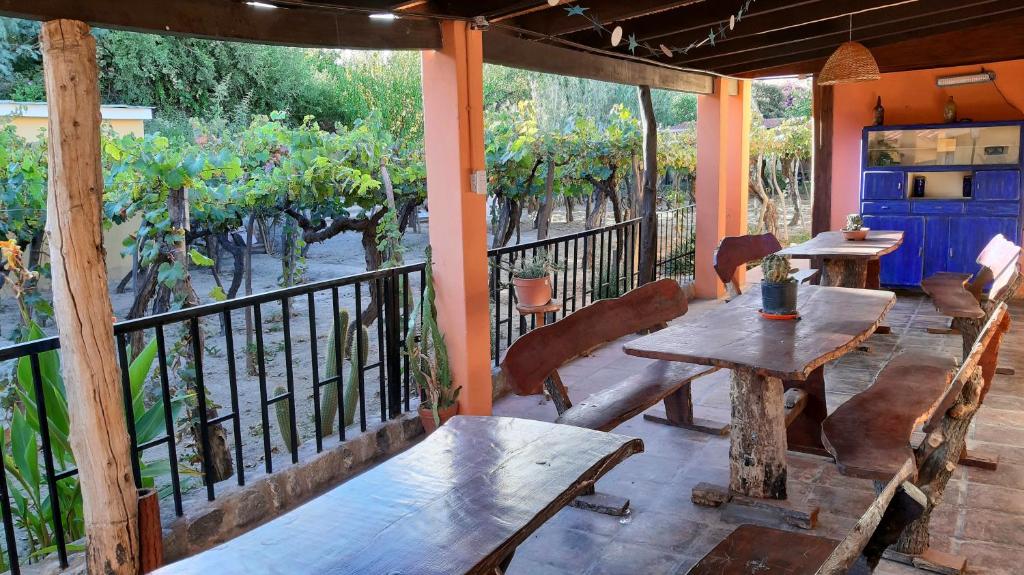a porch with wooden tables and benches on a balcony at MAMAKU HUASI in Cafayate