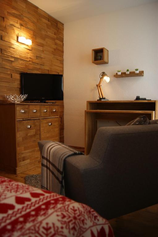 a hotel room with a tv and a couch and a chair at Hotel Schweizerhof in Engelberg