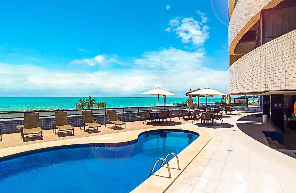 a swimming pool with a view of the ocean at Hotel Reymar Express in Maceió