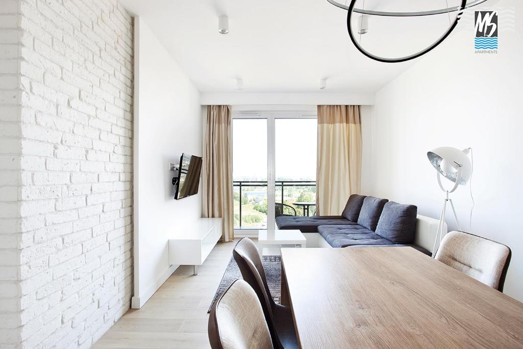 ein Wohnzimmer mit einem Tisch und einem Sofa in der Unterkunft MS Apartments Sky Tower VIII in Danzig