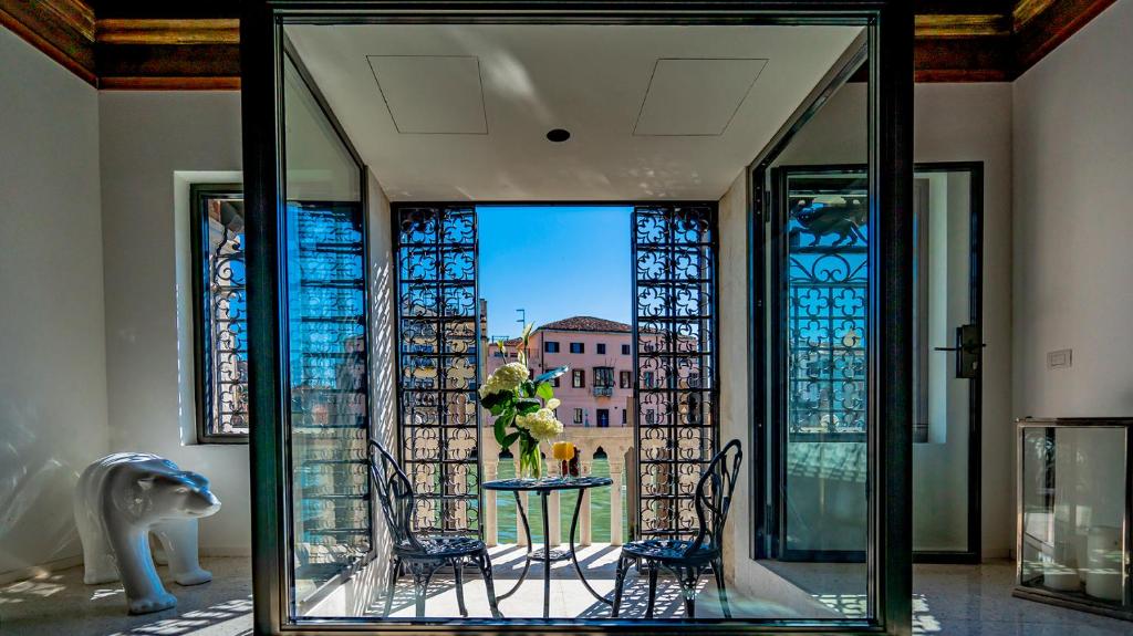 ein Glaszimmer mit einem Tisch und Stadtblick in der Unterkunft La Loggia Grand Canal in Venedig