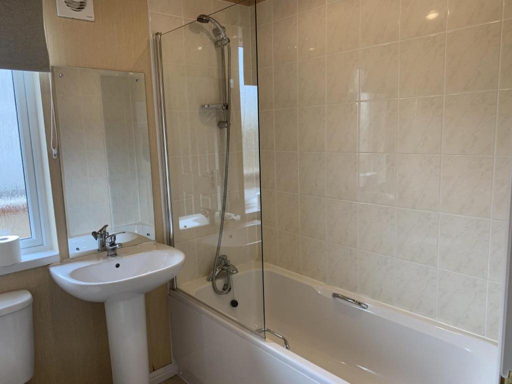 a bathroom with a sink and a shower at Barton Lodge in Penrith