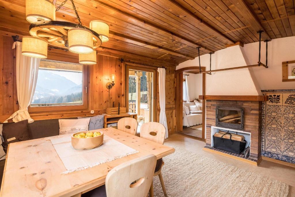 ein Esszimmer mit einem Tisch und einem Kamin in der Unterkunft Ferienhaus Moarbach in Floronzo