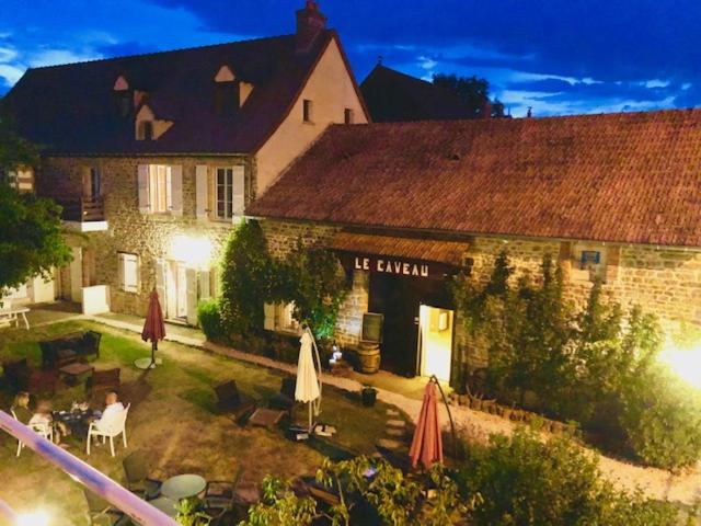 - un grand bâtiment avec une cour et une terrasse dans l'établissement Domaine de Vandenesse & Spa, à Vandenesse-en-Auxois