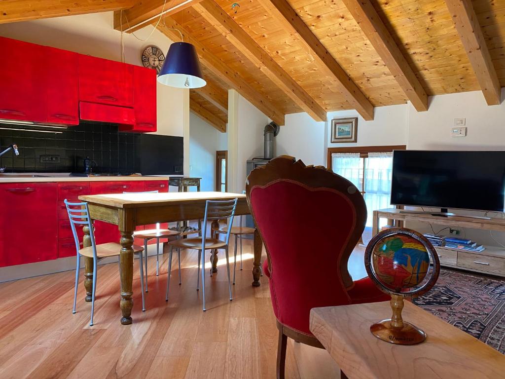 a kitchen with red cabinets and a table and chairs at La Casa al Torrente in Riva del Garda