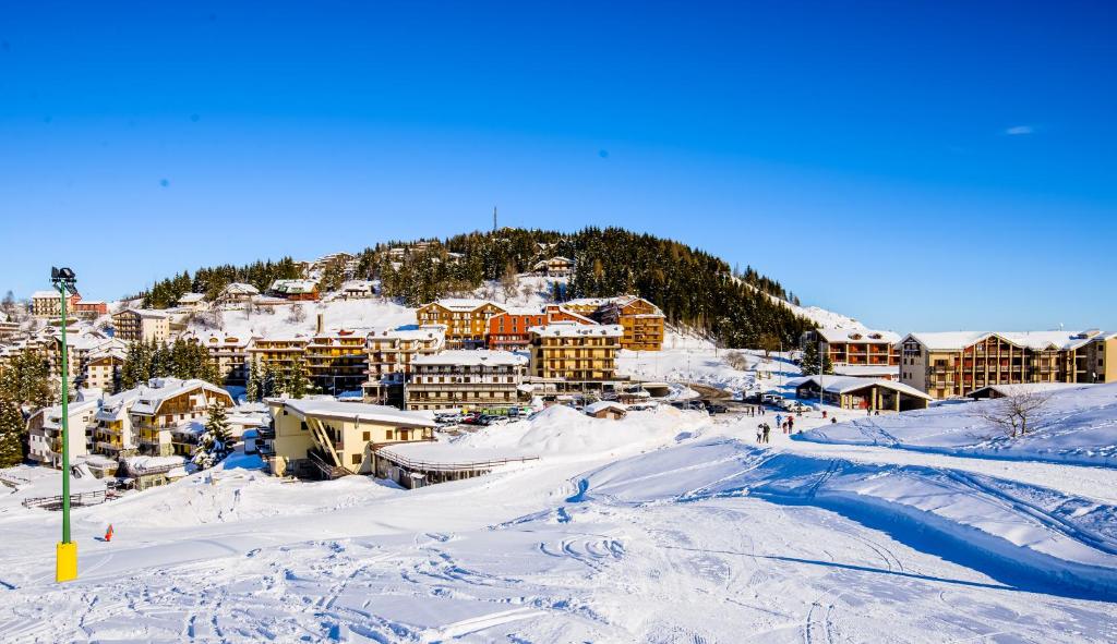 una città ricoperta di neve con una montagna di Appartamenti al Prel a Prato Nevoso