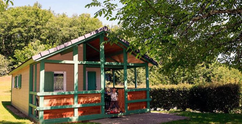 Une petite maison avec une femme debout à l'extérieur dans l'établissement chalets19hameauxduperrier.com, à Lissac-sur-Couze