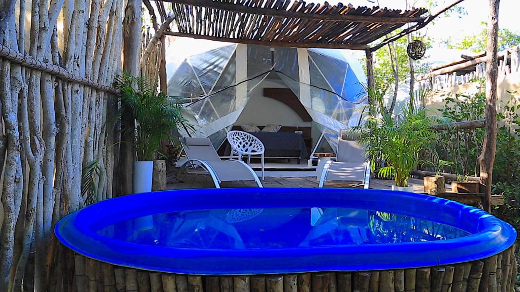 a large blue tub in a backyard with a tent at Glamping Tulum with private mini pool in Tulum