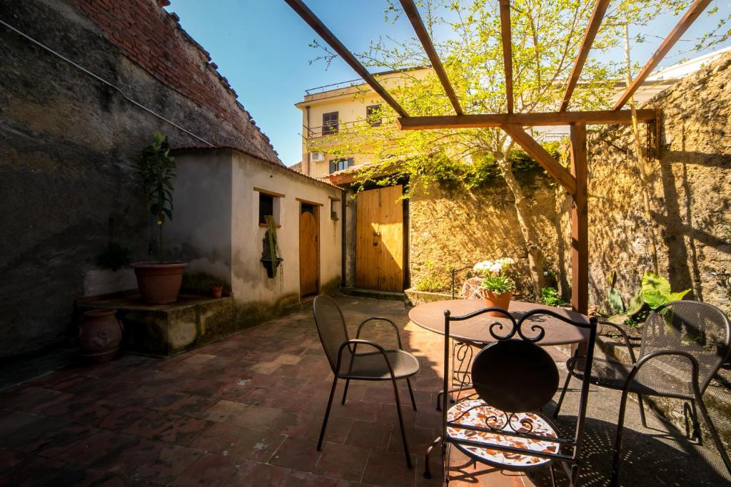 een patio met stoelen en een tafel op een binnenplaats bij Adelina e il bosso in Policastro Bussentino