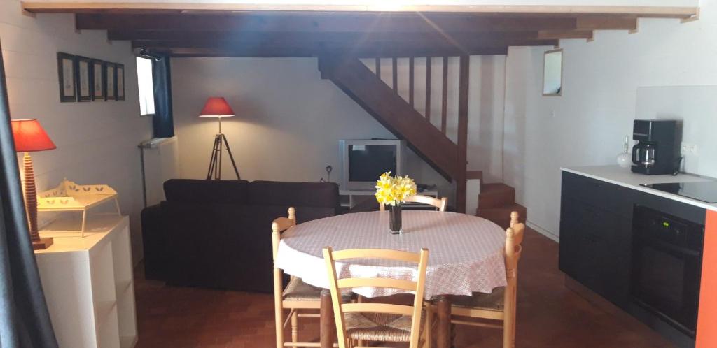 a kitchen and dining room with a table and a couch at gite 2 ou 3 personnes - campagne in Bourbriac