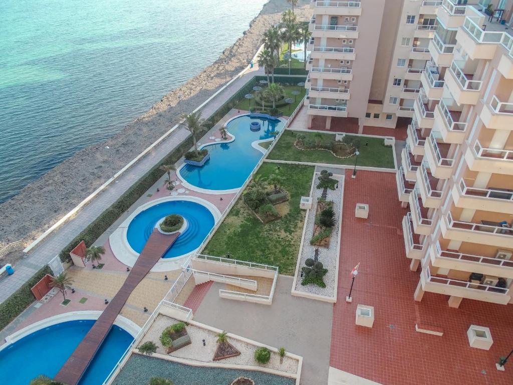 una vista aérea de un edificio con piscinas en Apartamentos Punta Cormorán, en La Manga del Mar Menor