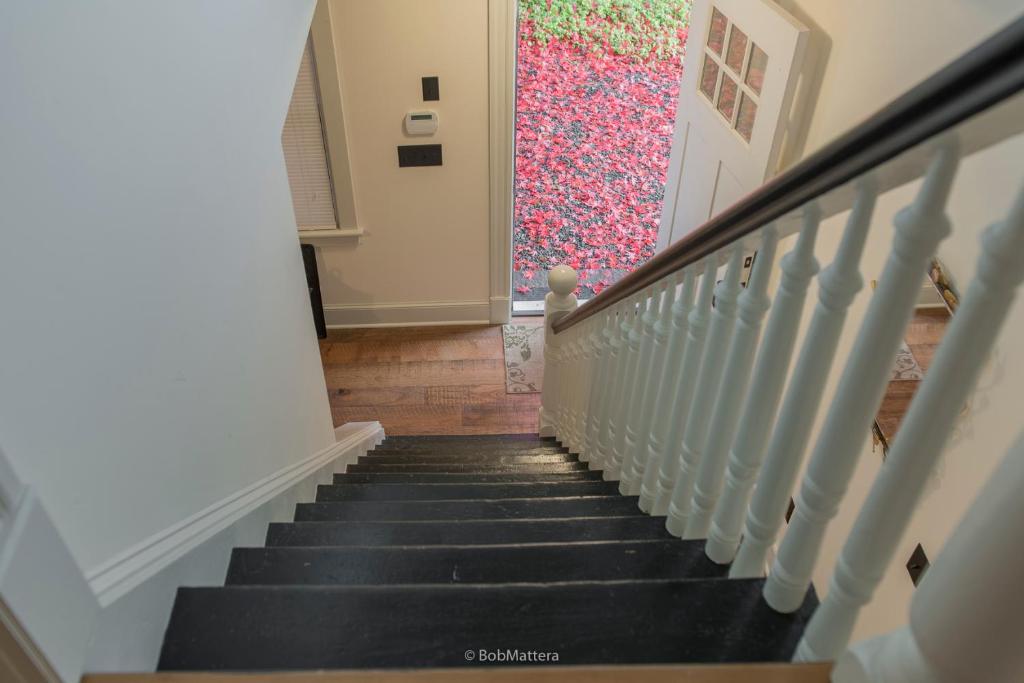una escalera que conduce a una puerta con una pintura en la ventana en Restored 1881 Farm House, en Lenox