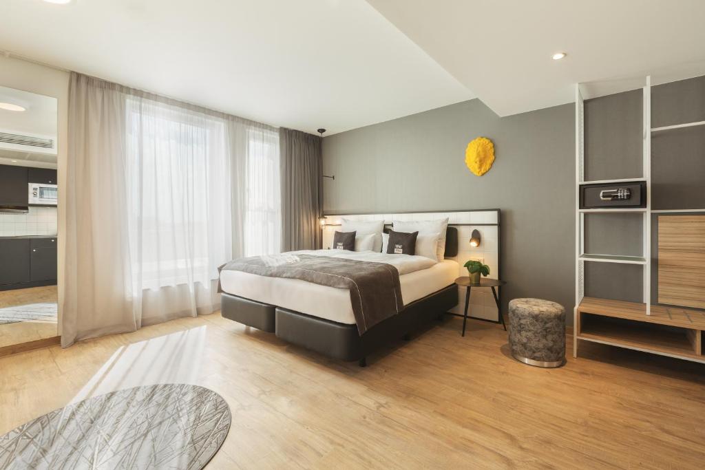 a bedroom with a large bed and a large window at the niu Leo - Apartments in Nürnberg