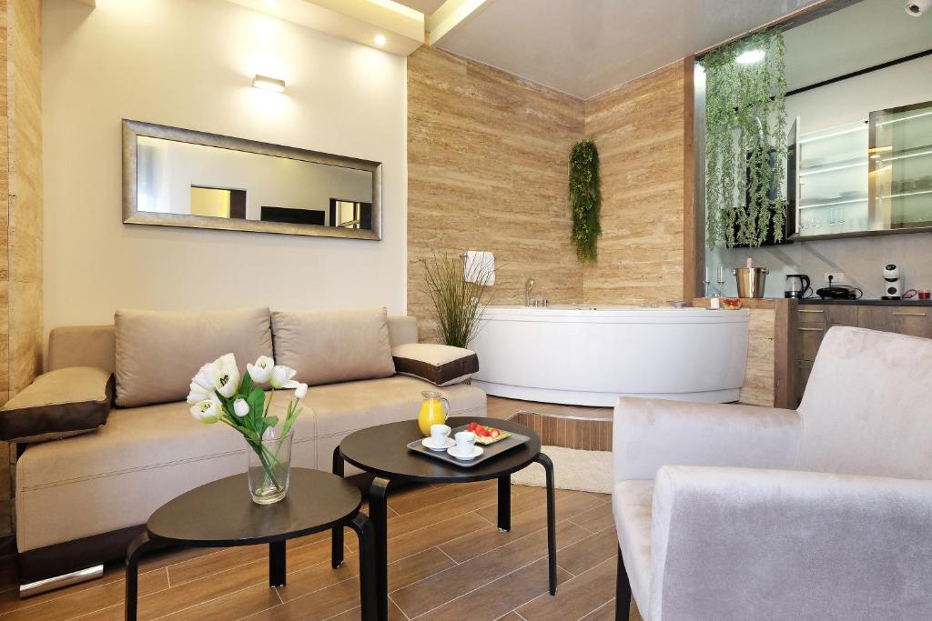 un soggiorno con un divano e una vasca da bagno di Central SPA Galaxy Apartment a Belgrado